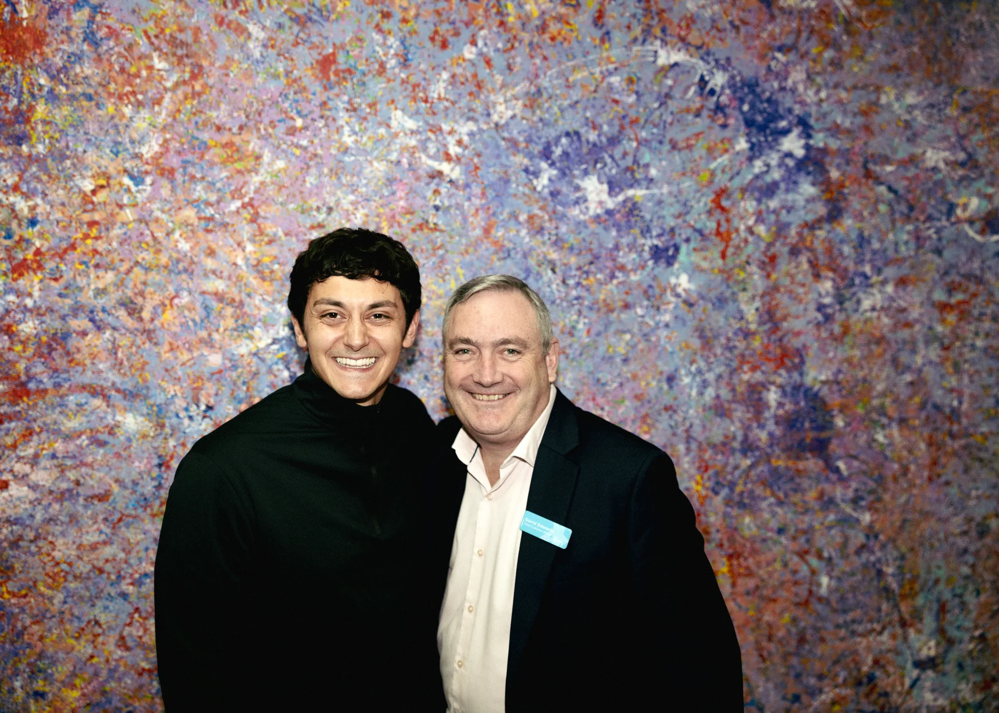 Keoki Alexander-Chang and David Edwards of Ability WA standing together in front of a large, colourful abstract painting